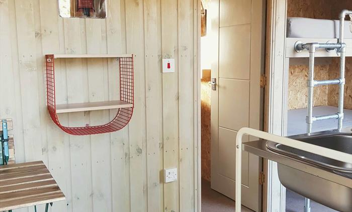 the inside of a wooden cabin with a door and beds